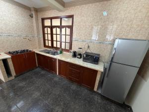 a kitchen with a stainless steel refrigerator and a sink at Altos de Belgrano Suites in Tarija