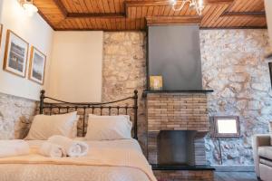 a bedroom with a bed and a fireplace at Κτήμα Βασίληγιάννη in Kouklésion