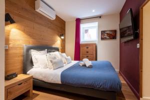 a bedroom with a bed with a blue ottoman at APPENNINS Annecy Rent Lodge in Annecy