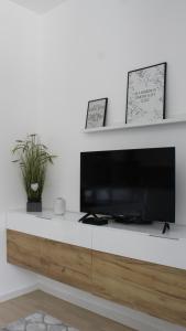 a living room with a television on a white wall at Apartman Lejla in Bjelašnica