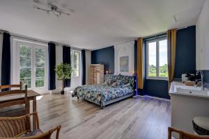 a bedroom with blue walls and a bed and windows at lemasrocamour in Roquemaure +33 photos