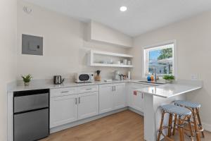a white kitchen with white cabinets and a window at Sailors Knot in Cocoa Beach