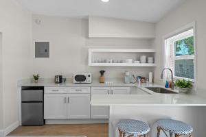 a white kitchen with white cabinets and a sink at Sailors Knot in Cocoa Beach