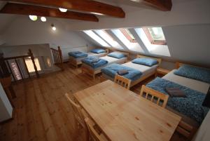 a attic room with four beds and a table at Noclegi Dywity Barczewskiego 27 in Dywity