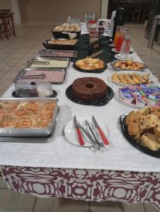a table filled with different types of pastries and cakes at Hotel Castro Alves Norte in Marília +10 photos