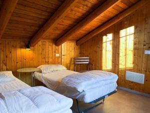 zwei Betten in einem Zimmer mit Holzwänden in der Unterkunft Panorama 3B - AffittiPontediLegno in Temù