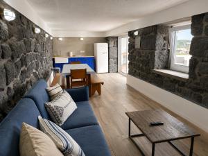 a living room with a blue couch and a table at Pico Island Villas 38 - Private Atlantic Retreat in Santo António