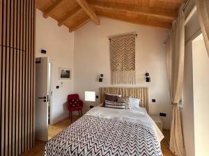 a bedroom with a bed and a red chair at Casa N'Aninhas - Santar in Santar