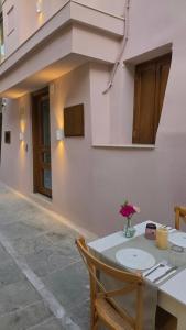 a white table with a vase of flowers on it at LUM Luxury Studios in Rethymno
