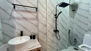 a white bathroom with a shower and a sink at The Yoyo's Stay in Arusha