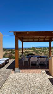a pavilion with a table and chairs on a patio at Stazzo gallurese Li Nibbareddhi in Aglientu