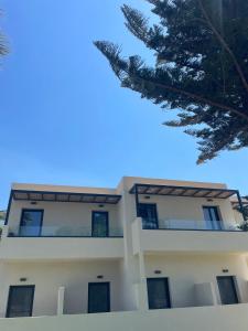 a large white building with a roof at Nikos Apartments & Studios in Plakias