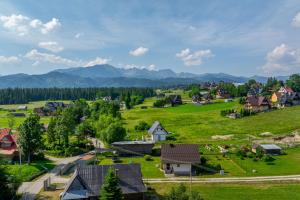 a small village with mountains in the background at Domek Przy Potoku Murzasichle in Murzasichle