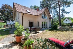 a house with a red bench in the yard at Lakeside Retreat Apartment in Bestensee