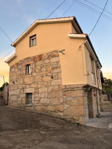a stone house with a stone wall at Casa Avoa María in Ourense