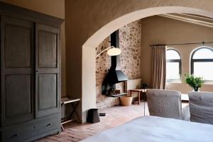 a room with a table and two chairs and a room with a fireplace at Hotel la Plaça Madremanya in Madremanya