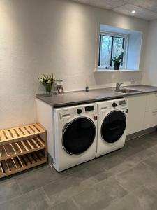 a kitchen with a sink and a washing machine at Varde Bed and Kitchen Annekset in Varde