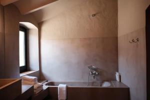 a bathroom with a bath tub and a window at Hotel la Plaça Madremanya in Madremanya +51 photos