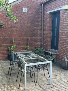 a glass table and chairs on a patio at Au cochon qui rit in Flines-lès-Mortagne +15 photos