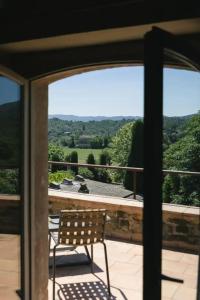 a chair on a balcony with a view of the countryside at Hotel la Plaça Madremanya in Madremanya