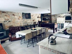 a kitchen with two tables and chairs and a stove at Casa Avoa María in Ourense
