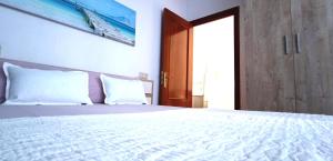 a bedroom with a white bed with a wooden door at Apartamento en Avilés Céntrico & Parking in Avilés +6 photos