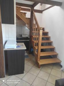 a kitchen with a wooden staircase in a room at Domek u Ewy w Spychowie in Spychowo