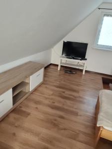 a living room with a flat screen tv in the attic at Domek u Ewy w Spychowie in Spychowo +3 photos