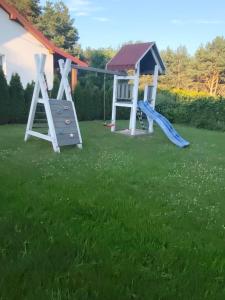 a playground with two swings and a slide at Domek u Ewy w Spychowie in Spychowo