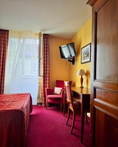a hotel room with a bed and a desk and a chair at Hôtel Restaurant Chez Henriette in Phalsbourg