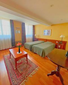 a hotel room with two beds and a table at Hôtel Restaurant Chez Henriette in Phalsbourg