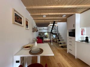 a kitchen and living room with a table and a staircase at Casa N'Aninhas - Santar in Santar