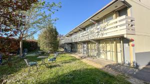 a building with chairs and tables in the yard at The Originals City, Hôtel Cap Sud, Avignon in Avignon +32 photos