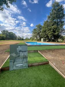 a sign in the grass next to a swimming pool at La Découverte Trouvée in Auxon