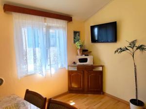 a living room with a table and a tv on the wall at Apartment Josip in Primošten