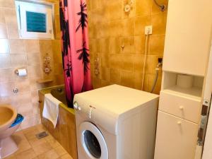 a small bathroom with a washing machine in it at Apartment Josip in Primošten +11 photos