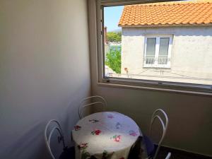a table and chair in a room with a window at Apartment Josip in Primošten