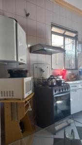 a kitchen with a stove and a microwave at Apartamento in Montes Claros +10 photos