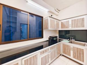 a kitchen with wooden cabinets and a large window at ความเจริญที่เงียบสงบ in Bangkok