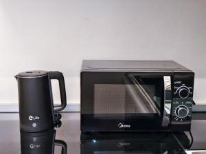 a black toaster oven and a coffee pot on a counter at ความเจริญที่เงียบสงบ in Bangkok