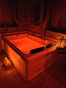 a large wooden tub in a room with candles at AL RANCH WELLNESS Cortina Lago Cadore Dolomiti in Pieve di Cadore