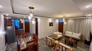 a living room with a couch and a table and chairs at The Yoyo's Stay in Arusha +23 photos