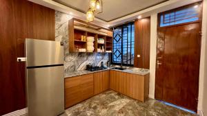 a kitchen with a refrigerator and a window at The Yoyo's Stay in Arusha