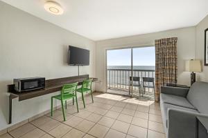 a living room with a couch and a table and chairs at SureStay Studio by Best Western Virginia Beach Oceanfront in Virginia Beach