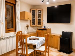 a small kitchen with a table and a television on the wall at Casa Ilera II, en el corazon de Rioja Alta 8 PAX in Casalarreina