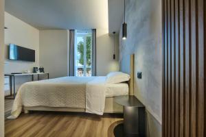 a bedroom with a bed and a table and a window at Monolocale 1 - via Sassi, Lecco in Lecco