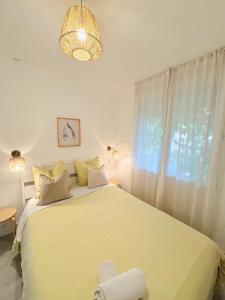 a bedroom with a large white bed with a window at La lavande in Arles