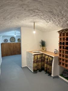 a dining room with a table and a wine cellar at CUEVA RURAL PALAPA DEL PERAL in El Charcón
