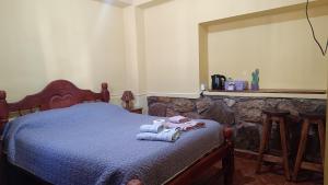 a bedroom with a bed with towels on it at El MasSi in Tilcara