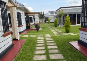 a garden with a stone pathway in front of a house at Mavana Cottages in Ol Pejeta Conservancy +10 photos